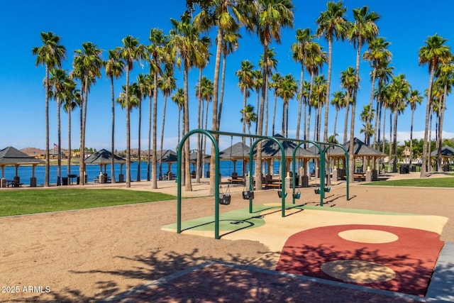 surrounding community featuring a gazebo, a playground, and a water view