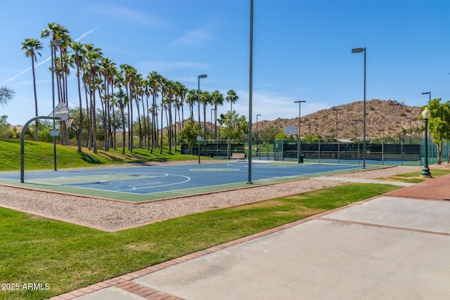 view of basketball court with a mountain view, tennis court, and a lawn