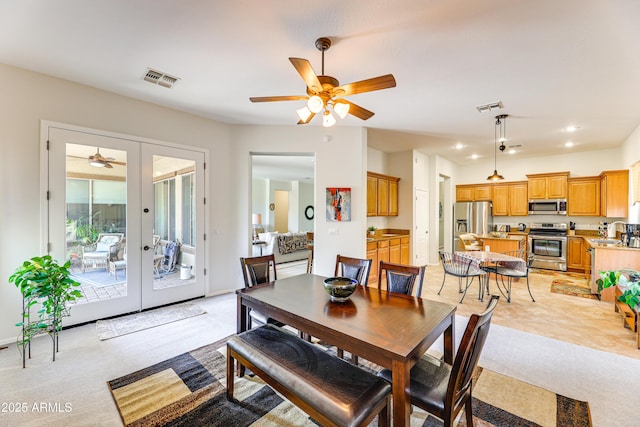 carpeted dining space featuring french doors, ceiling fan, and sink