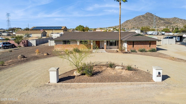 ranch-style home with fence and a mountain view