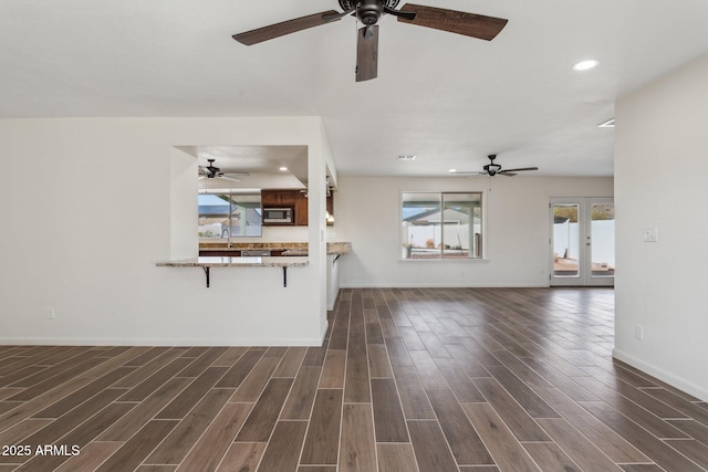 unfurnished living room featuring dark wood-style floors, french doors, baseboards, and recessed lighting