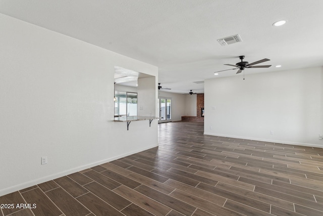 unfurnished living room featuring wood finish floors, recessed lighting, visible vents, ceiling fan, and baseboards