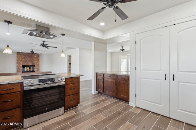 kitchen with light stone counters, wood finish floors, pendant lighting, open floor plan, and stainless steel range with electric cooktop