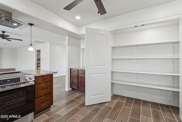 kitchen featuring stainless steel electric range oven, a ceiling fan, light stone countertops, and wood tiled floor