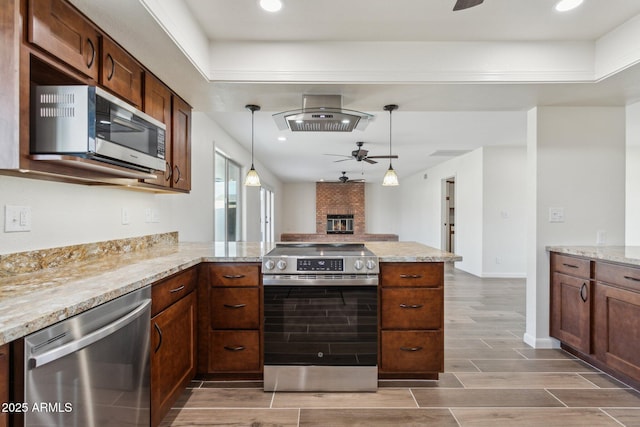 kitchen featuring a peninsula, wood tiled floor, appliances with stainless steel finishes, and a ceiling fan