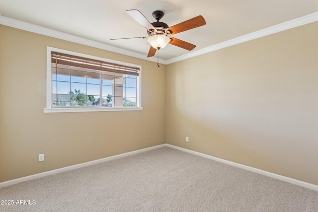 carpeted empty room with ceiling fan, baseboards, and crown molding