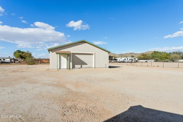 view of outbuilding with fence and an outbuilding