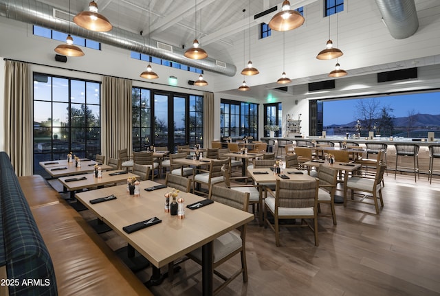 interior space with visible vents, a high ceiling, and wood finished floors