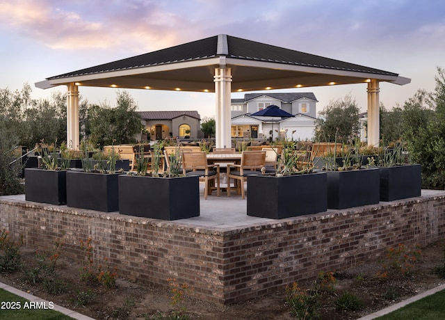 view of patio with a garden and a gazebo