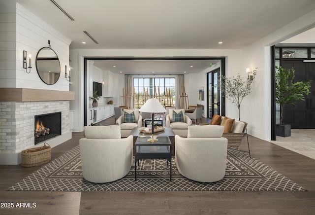 living room featuring wood finished floors, a fireplace, and recessed lighting