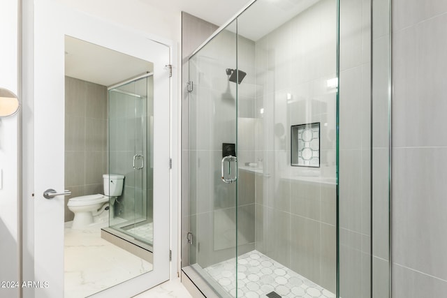 bathroom with toilet and a shower with shower door