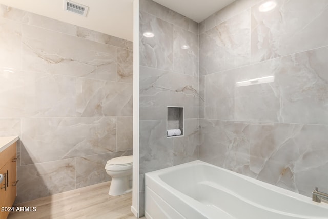 bathroom featuring vanity, hardwood / wood-style floors, toilet, and tile walls