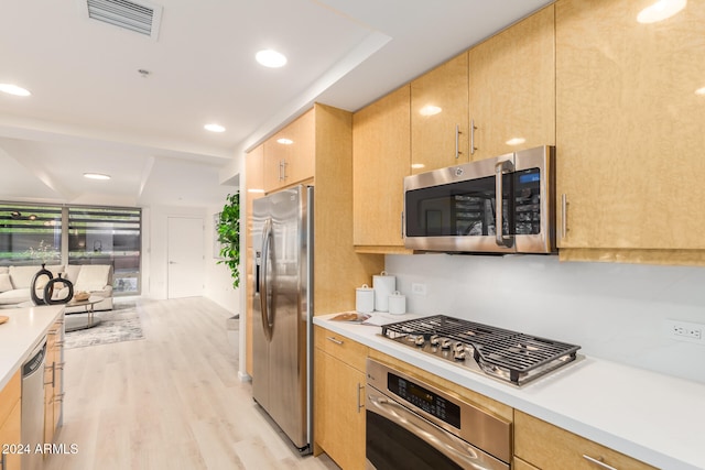 kitchen with appliances with stainless steel finishes, light hardwood / wood-style flooring, and light brown cabinets