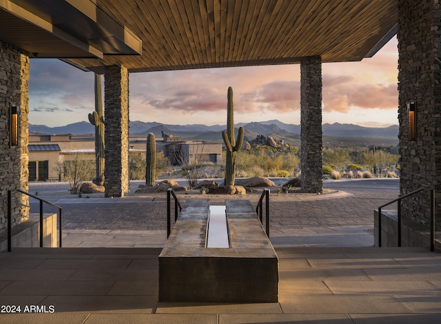 patio terrace at dusk featuring a mountain view