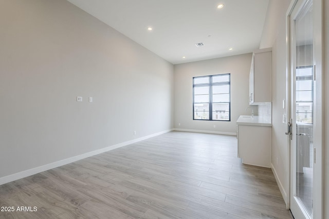 spare room featuring sink and light wood-type flooring