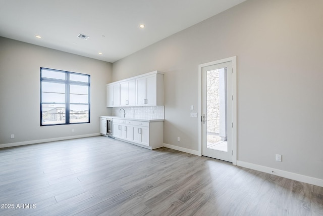 interior space featuring sink, beverage cooler, and light hardwood / wood-style flooring