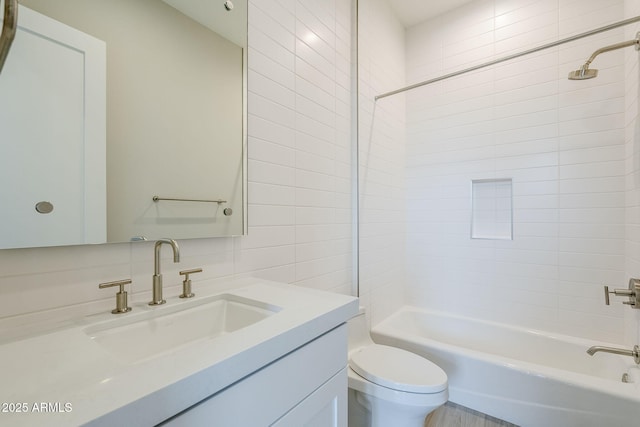 full bathroom with vanity, tiled shower / bath combo, and toilet