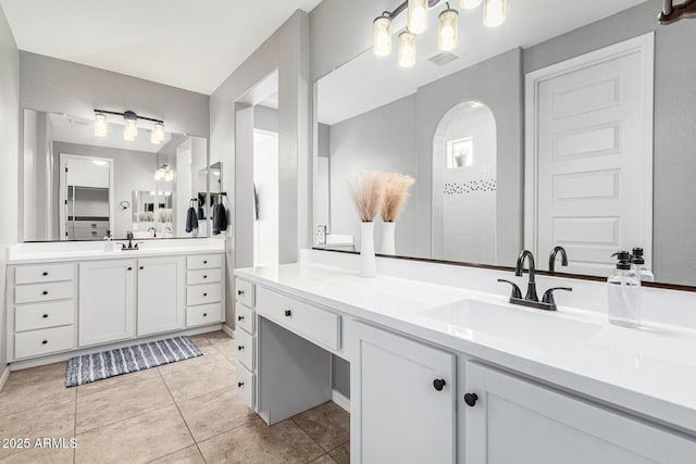 bathroom with tile patterned flooring, a shower, and vanity