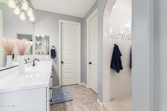 bathroom featuring tiled shower, vanity, and tile patterned floors