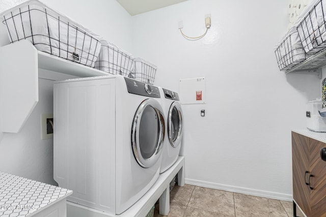 laundry area with washer and dryer and light tile patterned flooring