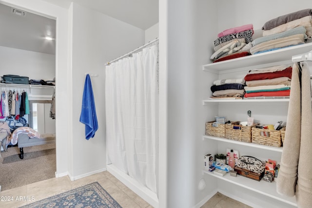 full bath featuring a shower with curtain, baseboards, visible vents, and tile patterned floors