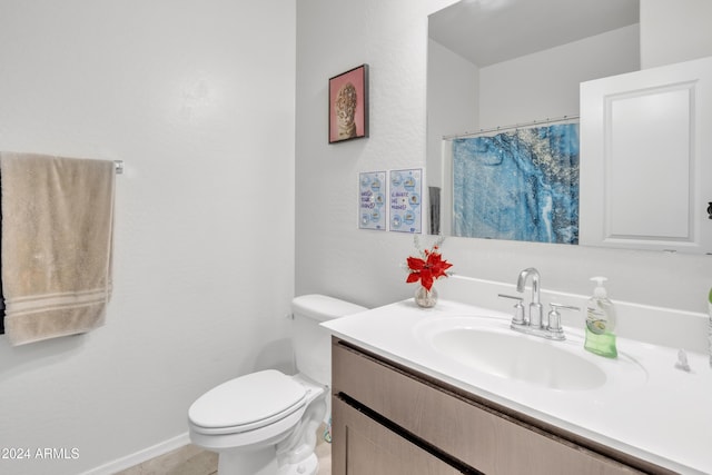 bathroom featuring toilet, a shower with shower curtain, and vanity