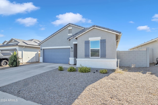 ranch-style house with a tile roof, stucco siding, fence, a garage, and driveway