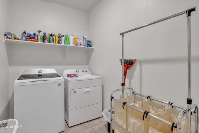 clothes washing area with light tile patterned floors, laundry area, and washer and clothes dryer