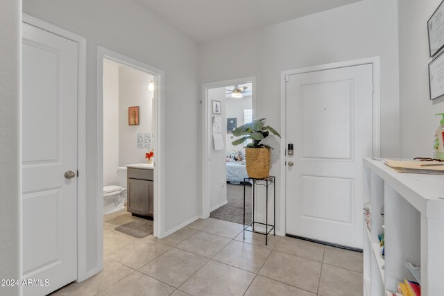 foyer entrance with light tile patterned floors, baseboards, and a ceiling fan