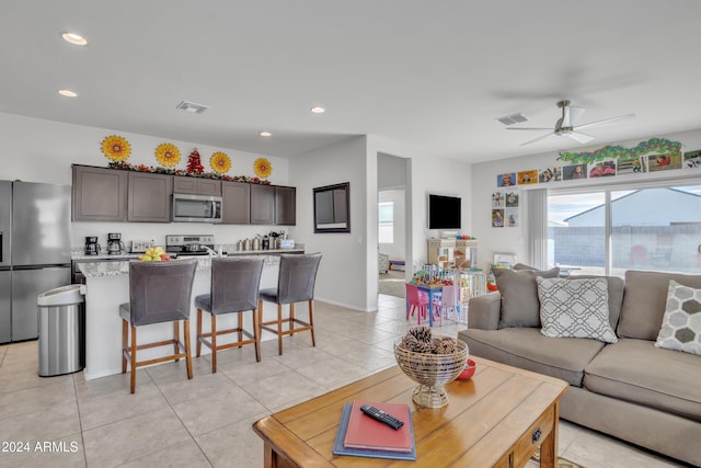 living room with ceiling fan and light tile patterned floors