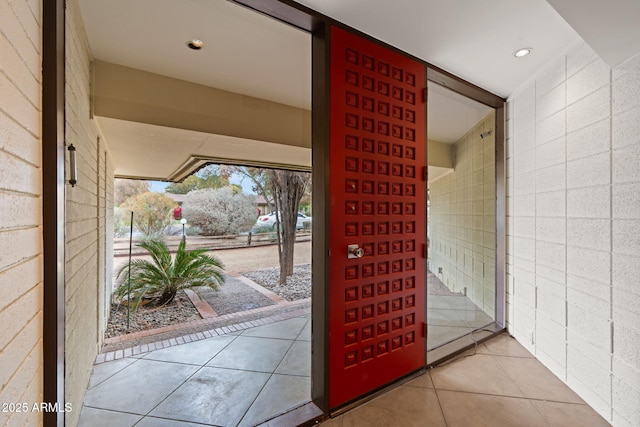 doorway to outside featuring light tile patterned floors and tile walls