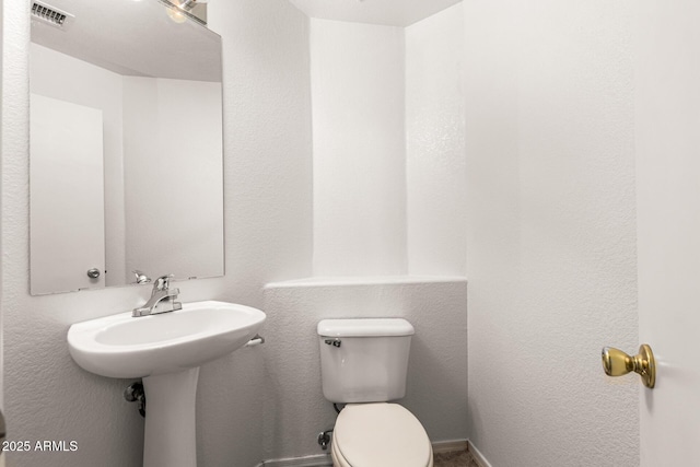 half bath with toilet and visible vents