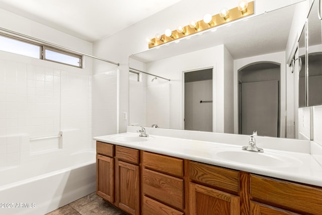 bathroom with double vanity, bathing tub / shower combination, and a sink