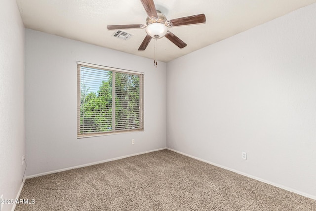 empty room featuring carpet floors, ceiling fan, visible vents, and baseboards