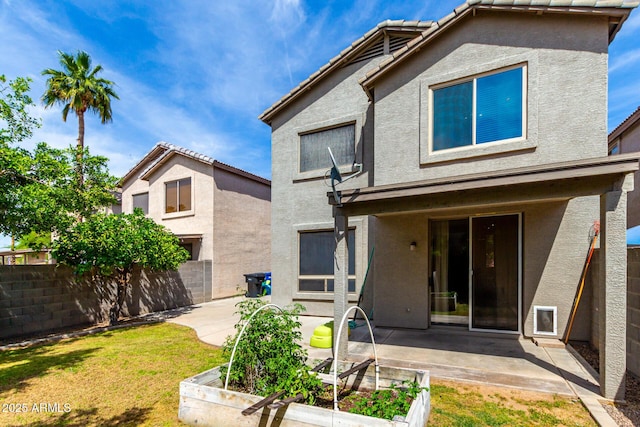 rear view of property featuring a patio, a fenced backyard, and stucco siding