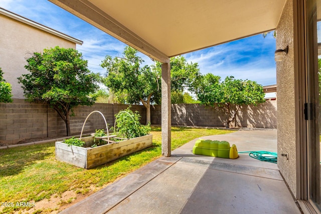 view of patio featuring a garden and a fenced backyard