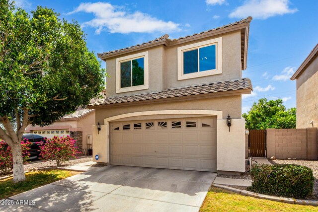 mediterranean / spanish-style house with concrete driveway, stucco siding, an attached garage, and a tile roof