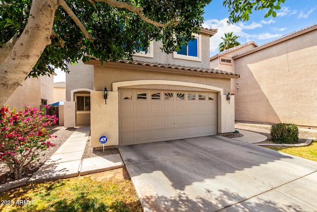 view of front of property with a garage, stucco siding, a tile roof, and concrete driveway