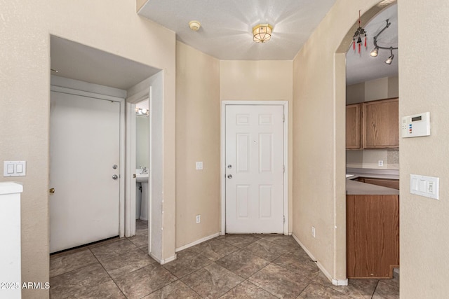 foyer featuring baseboards and tile patterned flooring