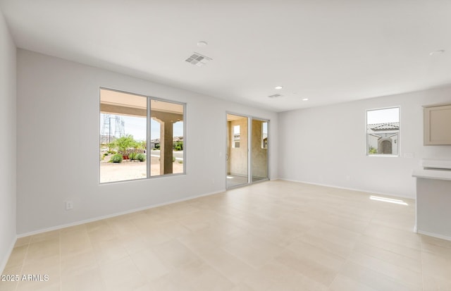 26995 W Adam Ave, Buckeye, AZ 85396 - unfurnished living room featuring healthy amount of natural light, baseboards, and recessed lighting