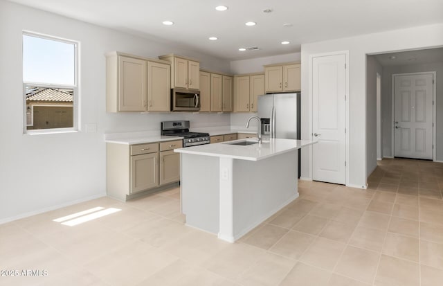 26995 W Adam Ave, Buckeye, AZ 85396 - kitchen featuring stainless steel appliances, a sink, cream cabinetry, light countertops, and a kitchen island with sink