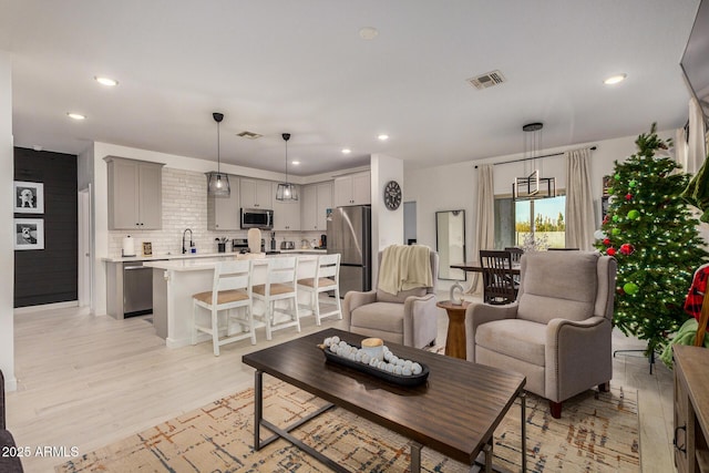 living room featuring light hardwood / wood-style floors and sink