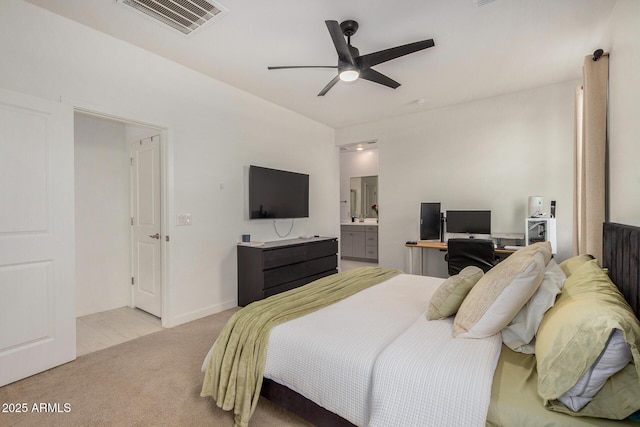 bedroom with ceiling fan, connected bathroom, and light colored carpet