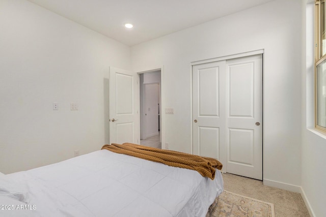 bedroom with light carpet and a closet