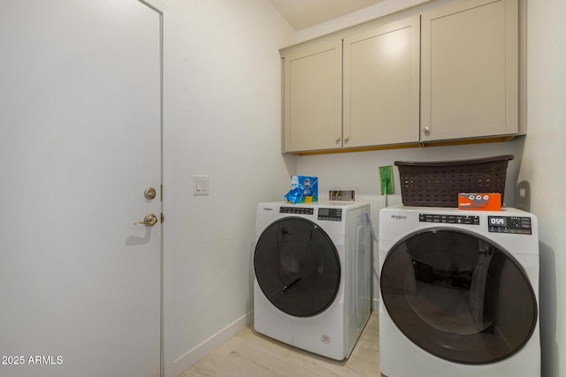 laundry room featuring washer and dryer and cabinets