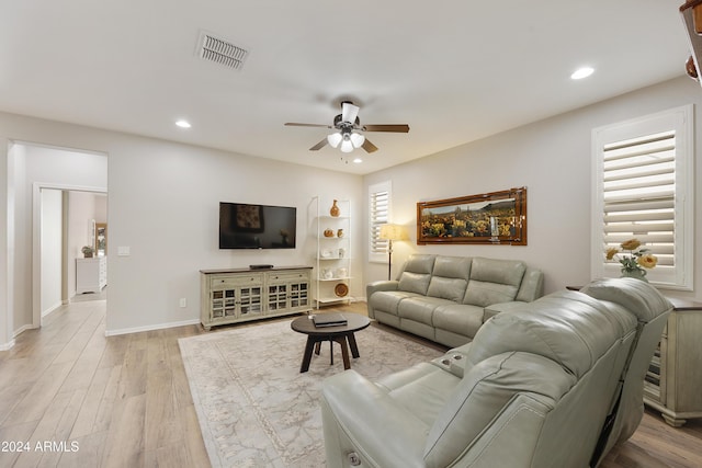 living room with light wood-type flooring, plenty of natural light, and ceiling fan