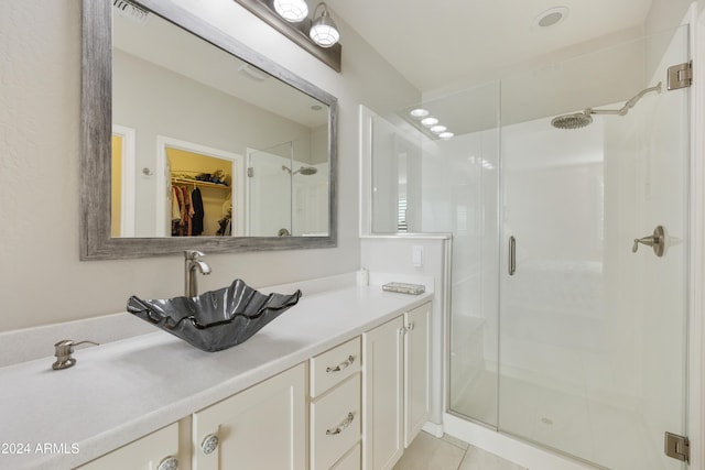 bathroom featuring tile patterned flooring, vanity, and an enclosed shower