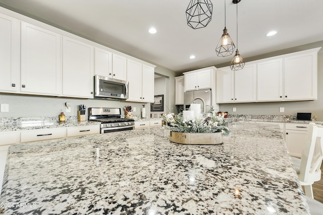 kitchen with a kitchen breakfast bar, decorative light fixtures, light stone counters, white cabinetry, and stainless steel appliances