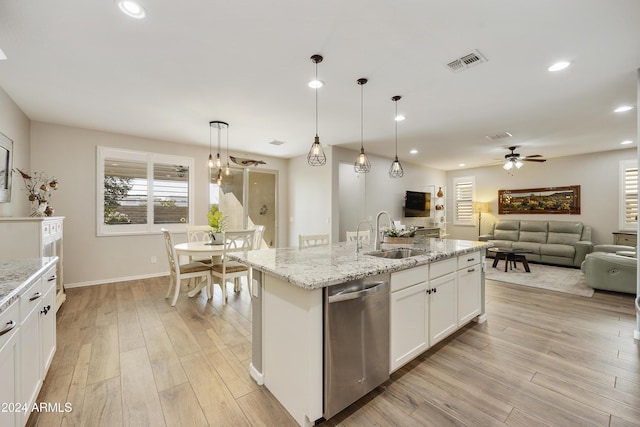 kitchen featuring pendant lighting, dishwasher, a kitchen island with sink, white cabinets, and sink