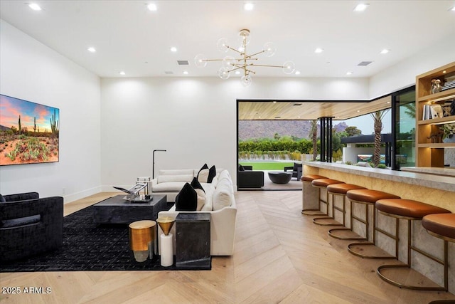 interior space with a chandelier, bar area, and light parquet floors